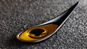 Cold pressed gingelly oil in glass bottle with sesame seeds